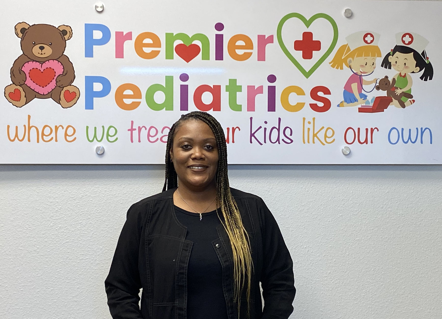 a portrait of Katina McLendon, CMA in front of the Premier + Pediatrics sig